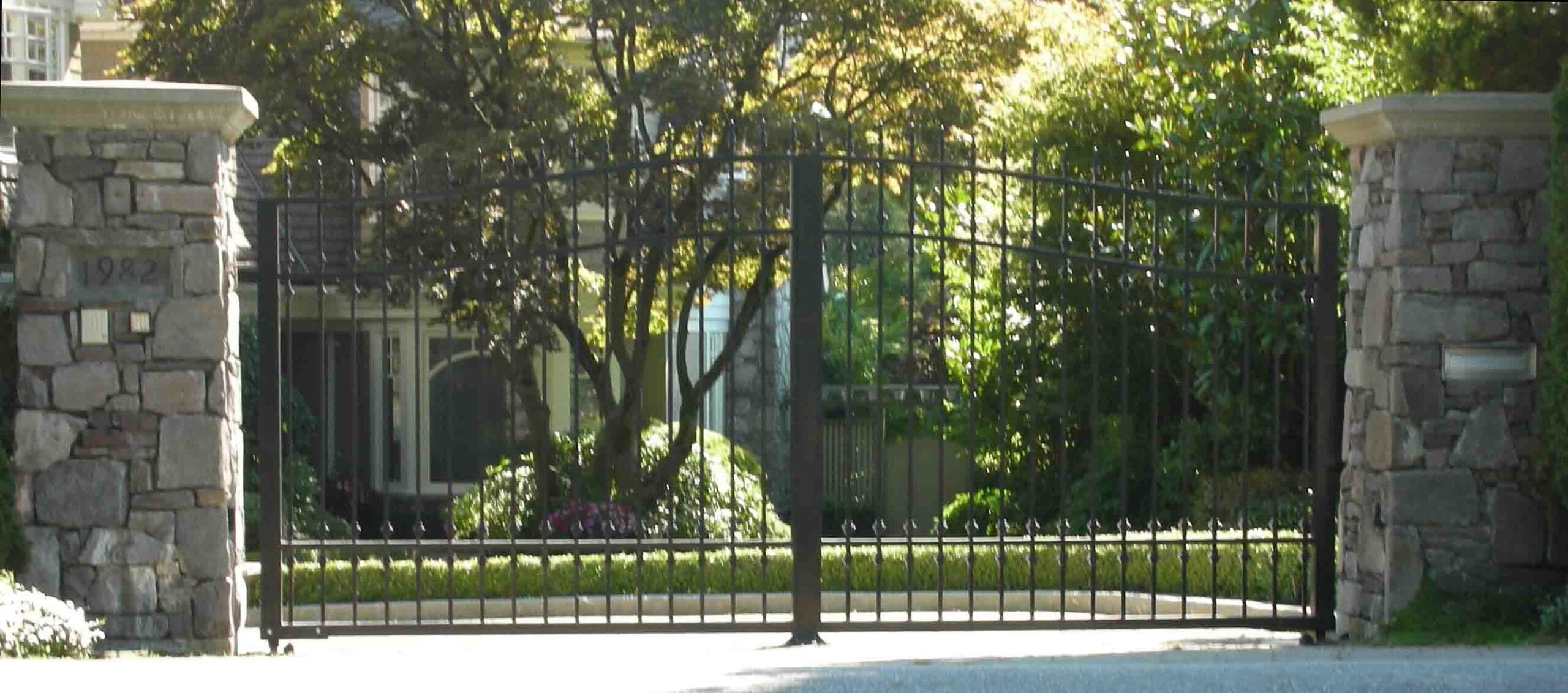 Wrought iron gate flanked by stone pillars