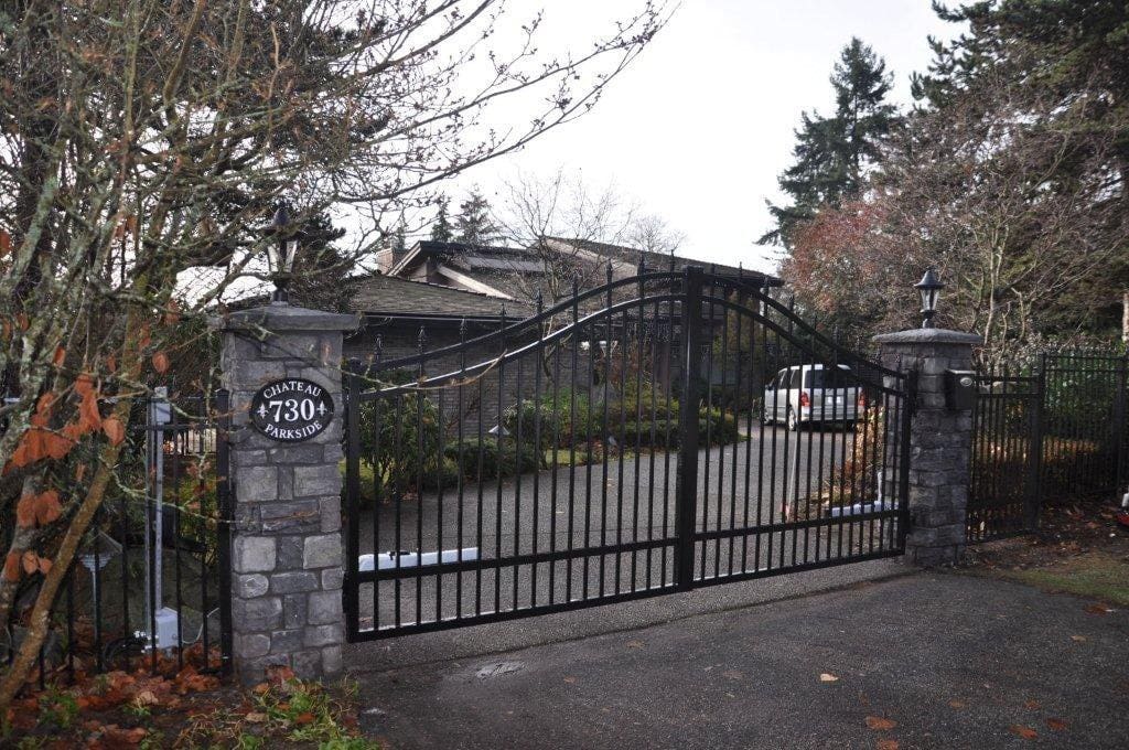 Wrought iron gates labeled "Chateau Parkside 730" open to a private driveway